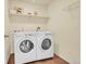 Functional laundry room with a front-load washer and dryer, and a shelf for storage, designed for convenience at 4884 St Vrain Rd, Firestone, CO 80504