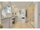 Well-lit main bathroom featuring double sinks, vanity area, a tiled shower, and an open door to the main bedroom at 4884 St Vrain Rd, Firestone, CO 80504