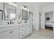 Bright bathroom featuring dual sinks with black hardware, a large mirror and modern fixtures at 1136 Hillside Ln, Louisville, CO 80027