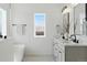 Bright bathroom featuring dual sinks with black hardware, a large mirror and modern fixtures at 1136 Hillside Ln, Louisville, CO 80027