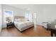 Bright bedroom with hardwood floors, a white accent wall, and a luxuriously made king bed at 1136 Hillside Ln, Louisville, CO 80027