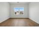Bright bedroom with hardwood floors and modern windows offering neighborhood views at 1136 Hillside Ln, Louisville, CO 80027