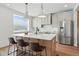 Modern kitchen island with seating, stainless steel appliances, and great natural light at 1136 Hillside Ln, Louisville, CO 80027