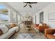 Bright living room with modern furniture, a ceiling fan, and an open floor plan that seamlessly connects to the kitchen at 1136 Hillside Ln, Louisville, CO 80027