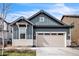 Stylish two-car garage home exterior with blue vertical siding and beige horizontal siding at 6311 Stable View St, Castle Pines, CO 80108