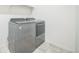 Updated laundry room features stainless steel washer and dryer units, and tile floor at 6311 Stable View St, Castle Pines, CO 80108