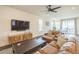 Cozy living area with a leather sectional, dark wood floors, and a ceiling fan for added comfort at 6311 Stable View St, Castle Pines, CO 80108