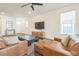 Comfortable living room with plush leather seating, a large TV, and natural light streaming in from the windows at 6311 Stable View St, Castle Pines, CO 80108