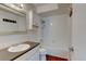 Clean bathroom with tub-shower, a new vanity, wood-look floors, and storage for toiletries at 3855 S Monaco St # 177, Denver, CO 80237