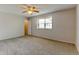 Carpeted bedroom features a ceiling fan and large window overlooking the backyard at 3855 S Monaco St # 177, Denver, CO 80237