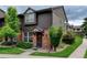 Charming two-story townhome with brick and wood exterior, front yard landscaping, and covered entryway at 3855 S Monaco St # 177, Denver, CO 80237
