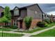 Attractive townhome exterior featuring brick facade, wood siding, manicured lawn, and sidewalk entrance at 3855 S Monaco St # 177, Denver, CO 80237