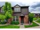 Inviting townhome with well-maintained lawn, mature trees, brick accents, and classic architectural design at 3855 S Monaco St # 177, Denver, CO 80237