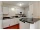 Charming kitchen features white cabinetry, black countertops and a double basin sink at 3855 S Monaco St # 177, Denver, CO 80237