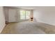 Bright and airy living room features a large window, neutral carpet, and ample space for versatile furniture arrangement at 3855 S Monaco St # 177, Denver, CO 80237