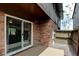 Back patio with sliding door, brick facade, wood trim and fencing for added privacy at 3855 S Monaco St # 177, Denver, CO 80237