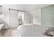 Bright bedroom features a sliding barn door to the bathroom, wood floors, and modern minimalist decor at 4408 E 107Th Pl, Thornton, CO 80233