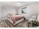 Bright bedroom featuring modern minimalist decor, wood floors and a large window at 4408 E 107Th Pl, Thornton, CO 80233