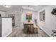 Well-lit dining room with skylight, wood floors, and stylish woven pendant light at 4408 E 107Th Pl, Thornton, CO 80233