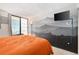 Stylish bedroom with sliding glass door to a balcony, television, and mountainscape wall art at 1020 15Th St # 9K, Denver, CO 80202