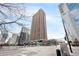 Street view of a tall apartment building with many balconies and businesses on the ground level at 1020 15Th St # 9K, Denver, CO 80202