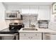 Well-maintained kitchen features stainless steel appliances, stone backsplash, and white cabinetry at 1020 15Th St # 9K, Denver, CO 80202