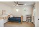 Bright bedroom featuring a wooden bed frame, blue quilt, and a ceiling fan at 10696 Riverbrook Cir, Highlands Ranch, CO 80126