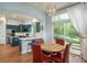 Open dining area with patio access, modern light fixture, and a view of the kitchen at 10696 Riverbrook Cir, Highlands Ranch, CO 80126
