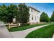 Exterior view of the home with mature trees and a green lawn at 10696 Riverbrook Cir, Highlands Ranch, CO 80126