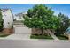 Charming two story house with stone veneer, a two car garage, and a mature tree in the front yard at 10696 Riverbrook Cir, Highlands Ranch, CO 80126