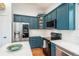 Modern kitchen with sleek stainless steel appliances, blue cabinets, and white countertops at 10696 Riverbrook Cir, Highlands Ranch, CO 80126