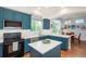 Contemporary kitchen with stainless steel appliances, blue cabinets, and barstool seating area at 10696 Riverbrook Cir, Highlands Ranch, CO 80126