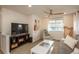 Comfortable living room featuring a large TV, ceiling fan, and cozy seating at 10696 Riverbrook Cir, Highlands Ranch, CO 80126