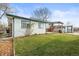 Exterior view of the home showcasing the backyard with green grass, mature trees and a shed at 10805 Verna Ln, Northglenn, CO 80234
