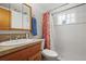 Bright bathroom featuring a classic vanity, medicine cabinet, and a shower with a patterned curtain at 10805 Verna Ln, Northglenn, CO 80234