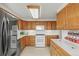 Classic kitchen with oak cabinets, white appliances, and tile countertops at 10805 Verna Ln, Northglenn, CO 80234