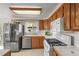 Well-lit kitchen with stainless steel refrigerator, oak cabinets and gas range at 10805 Verna Ln, Northglenn, CO 80234