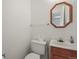 Simple powder room with a vanity, toilet, and decorative mirror, providing convenience for guests at 10805 Verna Ln, Northglenn, CO 80234