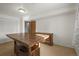 Carpeted room featuring a wooden table, dresser, and bright lighting, offering versatile space at 10805 Verna Ln, Northglenn, CO 80234