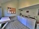 The shared laundry room is equipped with washers, dryers, a folding table, and a bulletin board at 371 S Estes St # 10, Lakewood, CO 80226