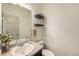 Neat half bathroom featuring a sink and vanity with decorative shelves above the toilet at 7877 E 139Th Pl, Brighton, CO 80602