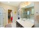Modern bathroom features double sinks, walk-in shower, tub, and walk-in closet with an arched doorway at 7877 E 139Th Pl, Brighton, CO 80602