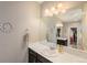 Bright bathroom featuring a large mirror, vanity, and stylish fixtures with walk-in closet view at 7877 E 139Th Pl, Brighton, CO 80602
