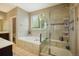 Bathroom with separate shower and tub, tiled floor, and plenty of natural light from the window at 7877 E 139Th Pl, Brighton, CO 80602