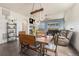 Dining area with rustic wooden table, comfortable seating, view of the fireplace and bright living room at 7877 E 139Th Pl, Brighton, CO 80602