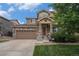 Charming two-story home featuring a stone facade, covered porch with star detail, and attached two-car garage at 7877 E 139Th Pl, Brighton, CO 80602