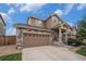 Home with a stone facade and an attached two-car garage and a cute porch with a patriotic star at 7877 E 139Th Pl, Brighton, CO 80602