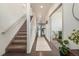 Bright hallway with hardwood floors, a staircase, and access to other rooms with natural light at 7877 E 139Th Pl, Brighton, CO 80602