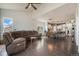 Open-concept living space featuring hardwood floors, a large sectional, and seamless transition to the kitchen at 7877 E 139Th Pl, Brighton, CO 80602