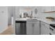 Stylish kitchen featuring a stainless steel dishwasher, white countertops, and a seamless flow to the dining area at 1818 S Quebec Way # 2-3, Denver, CO 80231